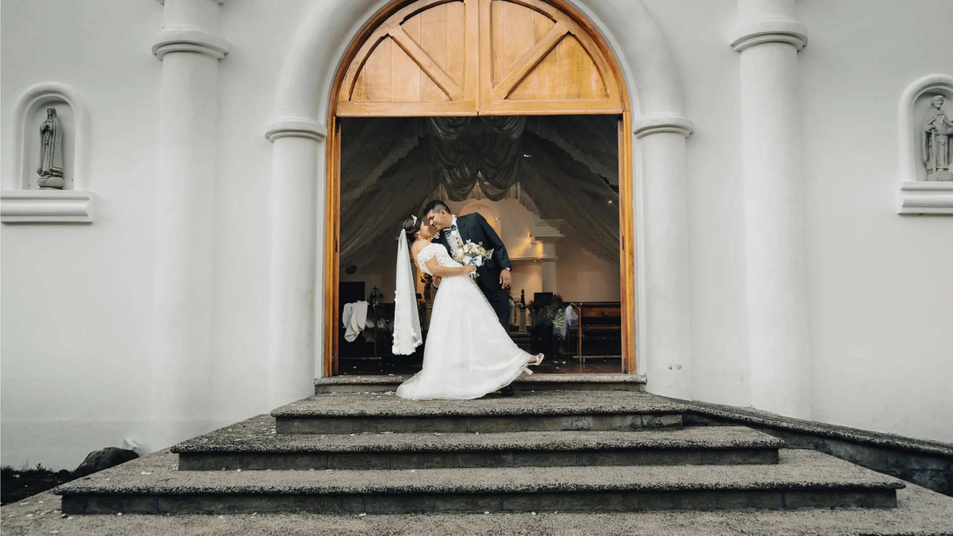 Los novios frente a la entrada de una iglesia